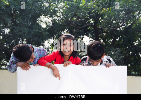 Bambini indiani in piedi con la Bacheca Foto Stock