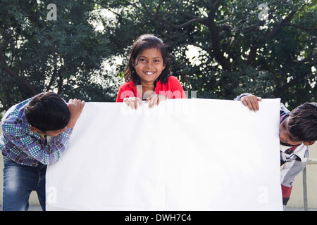 Bambini indiani in piedi con la Bacheca Foto Stock