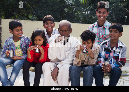 Rurale indiano bambini seduti con il nonno Foto Stock