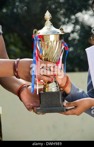 Donna indiana dando trofeo per bambini Foto Stock