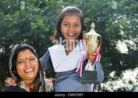 Donna indiana dando trofeo per bambini Foto Stock