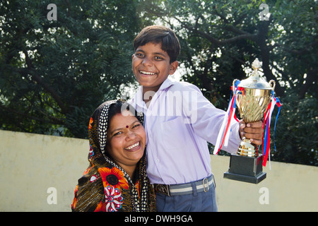 Donna indiana dando trofeo per bambini Foto Stock