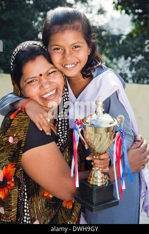 Donna indiana dando trofeo per bambini Foto Stock