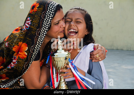 Donna indiana dando trofeo per bambini Foto Stock