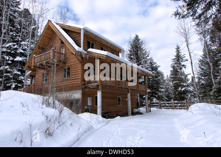 Log Cabin nella neve profonda nell'Idaho montagne Foto Stock