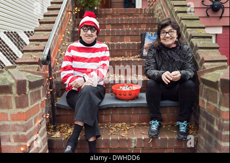 Donne in costume attendere a chinarsi per Halloween trucco o treaters nella sezione di Kensington di Brooklyn, New York. Foto Stock