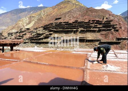 Markam. 9 Mar 2014. Un abitante di un villaggio lavora in una salina di nazionalità Naxi township di Markam contea di Qamdo Prefettura, a sud-ovest della Cina di regione autonoma del Tibet, 9 marzo 2014. La contea di Markam è conosciuto come un luogo con sale ricche di risorse. Da lontano, ci sono alcune 3,454 saline sulla scogliera piste e riverside in Naxi per far evaporare la soluzione salina al sole con un'ancestrale tecnica poiché la Dinastia Tang © 618-907 AD/Alamy Live News Foto Stock