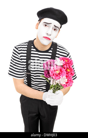 Triste artista mime tenendo un mazzo di fiori Foto Stock