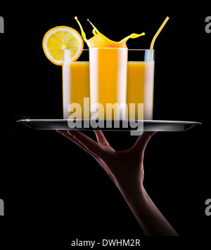 Il succo d'arancia fresco in vetro con splash isolata su uno sfondo nero Foto Stock