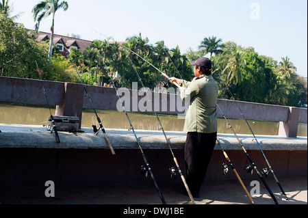 L'uomo la pesca lungo il fiume Ping marciapiede in Chiang Mai nel nord della Thailandia. Foto Stock