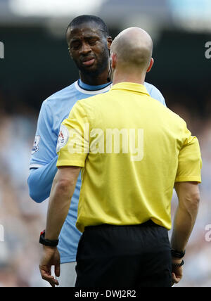 Manchester. 9 Mar 2014. Yaya Toure (L) del Manchester City reagisce dopo arbitro Anthony Taylor dà una pena possibilità di Wigan durante la FA Cup quarterfinal match tra Manchester City e Wigan al Etihad Stadium di Manchester, Gran Bretagna il 9 marzo 2014. Il Manchester City ha perso 1-2. © Wang Lili/Xinhua/Alamy Live News Foto Stock