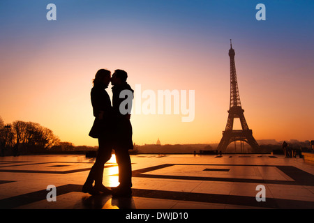 Amare giovane baciare sulla Torre Eiffel sfondo, Parigi, Francia Foto Stock