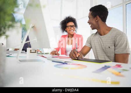 Felice informale gli editor di foto utilizzando tavoletta grafica Foto Stock