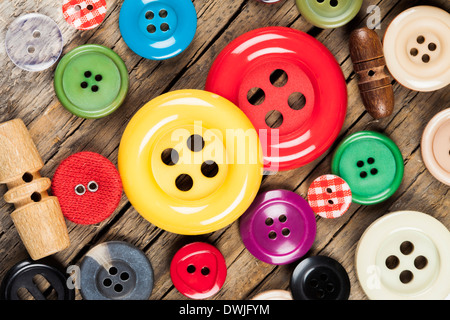 Set di colori pulsanti di cucitura su sfondo di legno Foto Stock