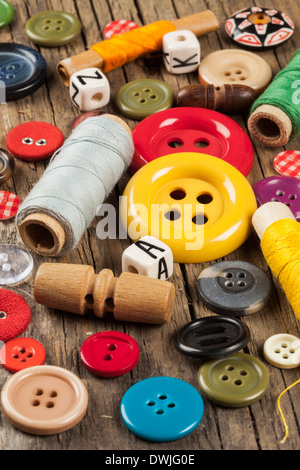 Set di colori pulsanti di cucitura su sfondo di legno Foto Stock