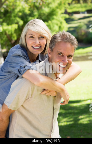 L uomo dando piggyback ride per donna Foto Stock