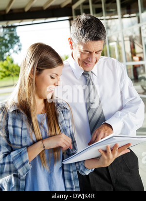 Il Professor spiegando studente di college Foto Stock