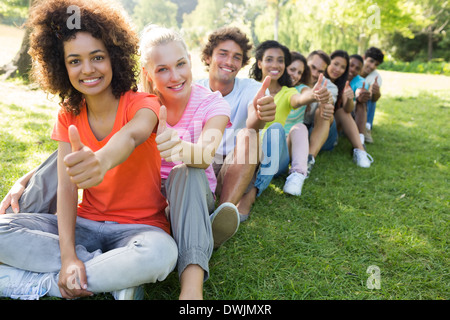 Gli studenti universitari gesticolando pollice in alto Foto Stock