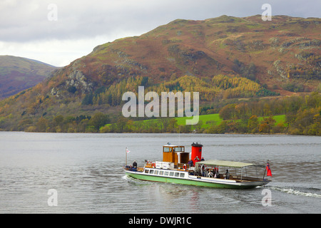 I turisti prendendo un viaggio su un battello a vapore (barca) un lago, con le colline in background. Foto Stock