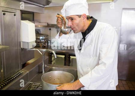 Maschio degustazione di cucinare il cibo in cucina Foto Stock