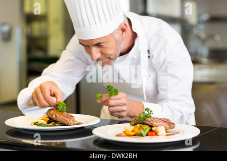 Concentrato chef maschio la farcitura di prodotti alimentari in cucina Foto Stock