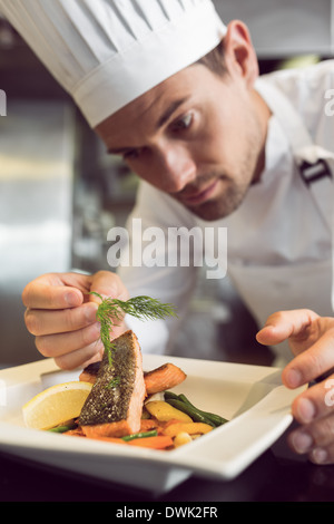 Primo piano di un concentrato di chef maschio la farcitura di prodotti alimentari Foto Stock