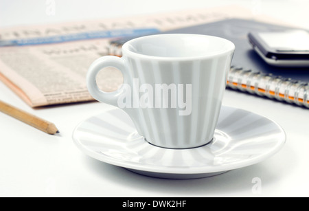 Tazza da caffè con giornali e smart phone sul tavolo per ufficio Foto Stock