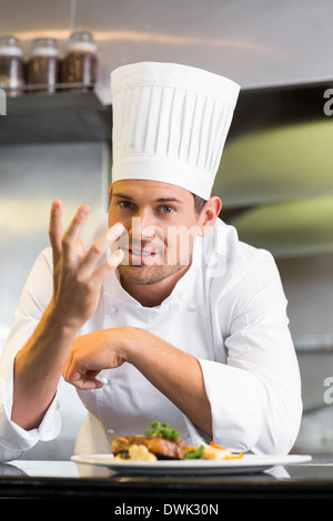 Sorridente chef maschio con cibi cotti in cucina Foto Stock