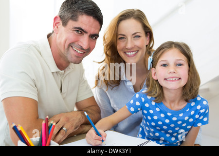 I genitori ad assistere la figlia di colorazione a casa Foto Stock