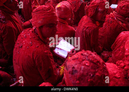 Barsana, India. 8 Mar 2014. In una vecchia tradizione gli uomini dal vicino villaggio di Nandgaon sedersi e faccia a faccia con gli uomini da Barsana e cantare le lodi di Krishna e Radha. Le persone sono coperti in polvere colore durante Lathmaar Holi o Lathmar Holi festival in Barsana. © Subhash Sharma/ZUMA filo/ZUMAPRESS.com/Alamy Live News Foto Stock