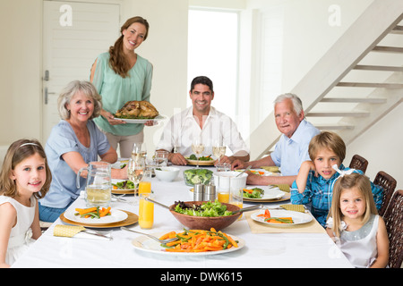 Famiglia avente pasto al tavolo da pranzo Foto Stock