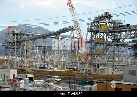 Domenica. 9 Mar 2014. Il 9 marzo, Rikuzentakada, Giappone - terra e sabbie dalle montagne vicine sono portati dai convogliatori a sollevare la terra in Rikuzentakada, nella prefettura di Iwate, domenica 9 marzo, 2014, sul alla vigilia del terzo anniversario del grande oriente giappone terremoto. Rikuzentakada è uno dei più colpiti delle comunità lungo il Giappone del nord-est costa del Pacifico hanno devastato dalla grandezza 9.0 del terremoto e del conseguente tsunami. Credito: Natsuki Sakai/AFLO/Alamy Live News Foto Stock