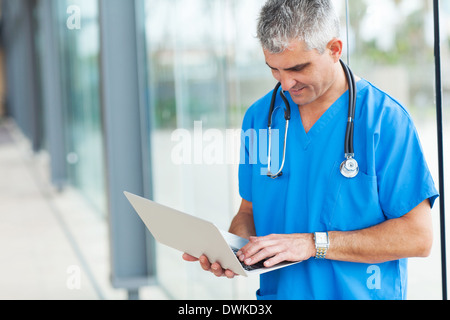 Moderno medico senior al lavoro su un notebook Foto Stock