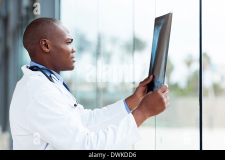Felice americano africano medico guardando il paziente x-ray in ufficio Foto Stock