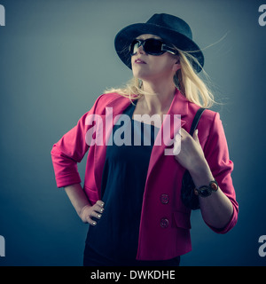 Urbano donna matura che indossa un paio di occhiali da sole e cappello, studio shot Foto Stock