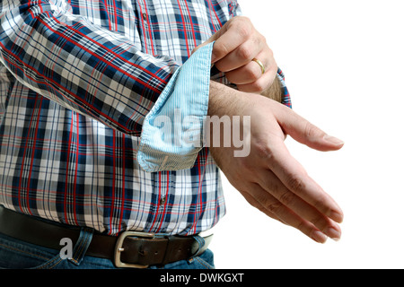 Uomo in jeans e un plaid shirt arrotola i suoi manicotti, isolati su sfondo bianco Foto Stock