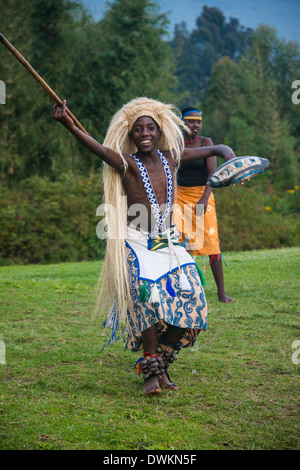 Uomo che porta una parrucca e una lancia ad una cerimonia di ex cacciatori di frodo, nel Parco nazionale di Virunga, Ruanda, Africa Foto Stock