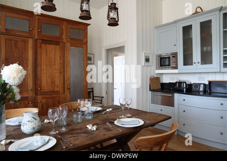 Moderno/tradizionale cucina con tavolo da pranzo, pavimento in legno e azzurro di unità Foto Stock