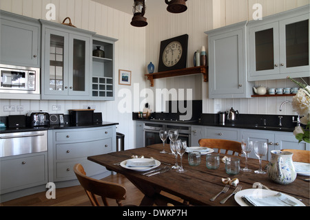 Moderno/tradizionale cucina con tavolo da pranzo, pavimento in legno e azzurro di unità Foto Stock