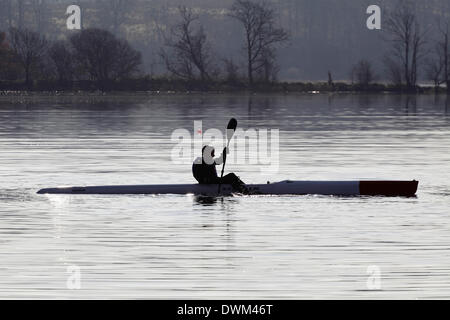 Castle Semple Loch, Lochwinnoch, Renfrewshire, Scozia, Regno Unito, martedì, 11 gennaio, 2014. Un canoista al sole della mattina presto nel Parco Regionale di Clyde Muirshiel Foto Stock