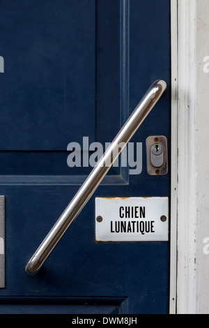 Segno su una porta anteriore nel Sussex, Regno Unito. Chien Lunatique, Mad Dog. Foto Stock