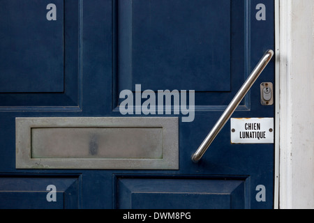 Segno su una porta anteriore nel Sussex, Regno Unito. Chien Lunatique, Mad Dog. Foto Stock