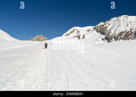 Gli alpinisti escursionismo in salita da sci alpinismo ed escursioni con le racchette da neve in Majestic di alta montagna sfondo alpino. Persone irriconoscibili. Foto Stock