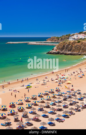 I turisti a prendere il sole in spiaggia ombrelloni sulla spiaggia sabbiosa a Praia do Tunel, spiaggia Albufeira, Algarve, Portogallo, Europa Foto Stock