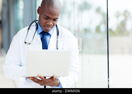 Professional americano africano medico maschio lavorando sul computer portatile Foto Stock