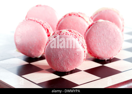 Rosa macarons francese su una scacchiera Foto Stock