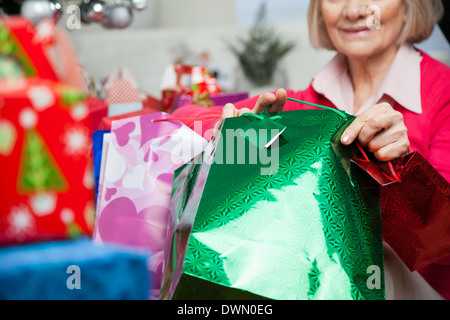 Senior donna sacchetti di contenimento durante il periodo di Natale Foto Stock