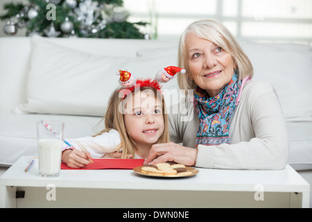 Ragazza e la nonna con Cardpaper a casa Foto Stock