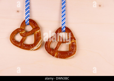 Due pretzel nella forma di cuore su uno sfondo di legno, vista dall'alto Foto Stock