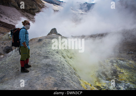 I turisti in piedi da fumo di fumarole sul vulcano Mutnovsky, Kamchatka, Russia, Eurasia Foto Stock